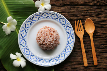 Cooked rice brown Jasmine From Thailand in ceramic dish on dark wood background 