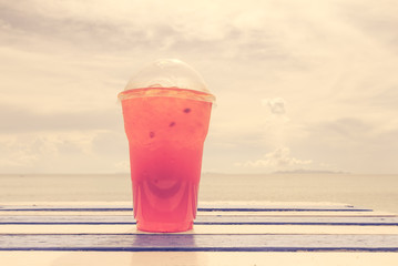 Cold drink on wooden table over summer blue sea,retro effect