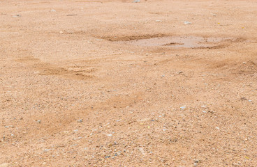 Closeup surface soil ground after rain with tire marks textured background