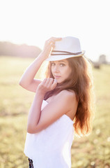 sweet young girl in a hat on the setting sun, sunset,selective focus 