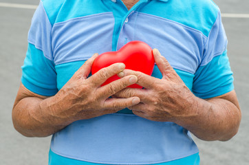 Old man holding heart because of heart infarction