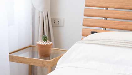 Close up white bedroom interior decor with cactus  flowerpot on table