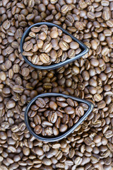 Roasted coffee beans of three different level in black bow on grunge wooden background
