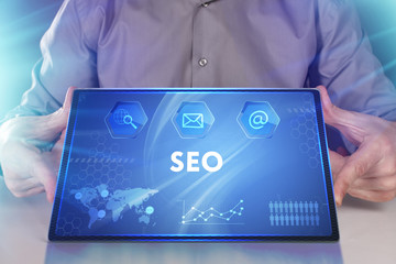 Business, Technology, Internet and network concept. Young businessman working on a virtual screen of the future and sees the inscription: SEO
