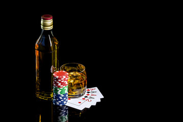 Bottle with glass whiskey and poker chips with cards