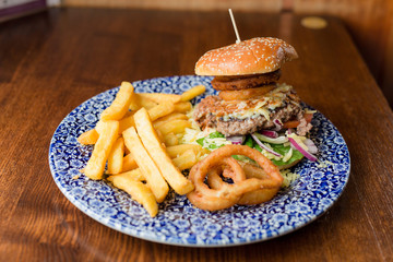 Frischer Burger mit Pommes und Zwiebelringe aus England