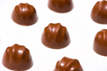 A lot of variety chocolates on white wooden background