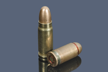 Pistol cartridges of caliber 7.62 mm and 9 mm on gray background