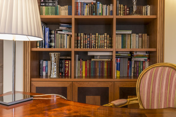 Wooden desk and classic bookcase with books