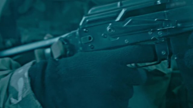 Soldier hand charging kalashnikov rifle. Assault rifle kalashnikov charging. Reloading ak47. Close up of charging machine gun. Soldier reloading weapon