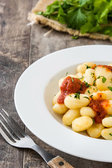 Gnocchi with tomato sauce on wooden background
