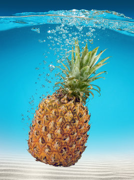 ripe pineapple falling into sea water