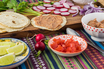 Ingredients for homemade vegetarian corn tacos with refried beans and vegetables.