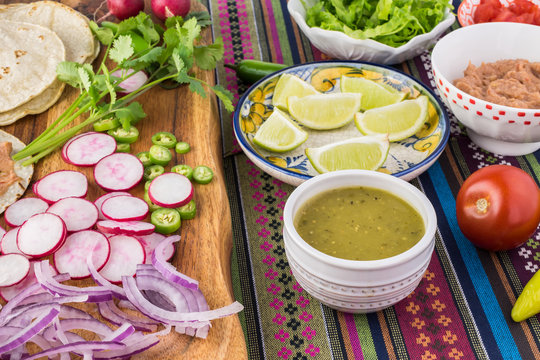 Ingredients for homemade vegetarian corn tacos with refried beans and vegetables.