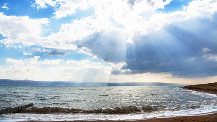 sunshine passes through blue clouds over Dead Sea