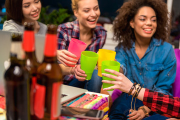 Cheerful ladies drinking beverage in room