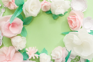 Round frame with color paper flower on green background.