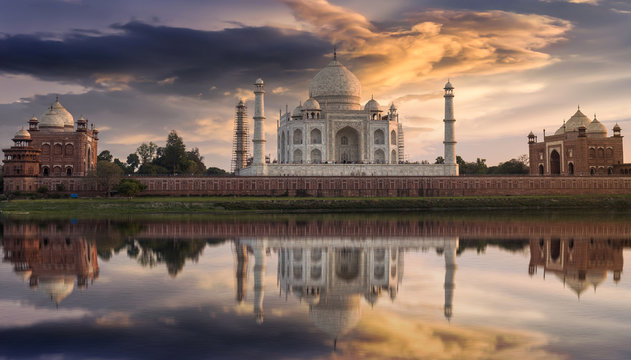 Taj Mahal Agra at sunset as seen from the Yamuna river banks with a moody sky. Taj Mahal designated as a World Heritage Site is a masterpiece of Indian heritage and architecture.