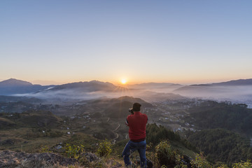 Fototapeta premium Photographer in action, clicking a beautiful Himalayan Sunrise.