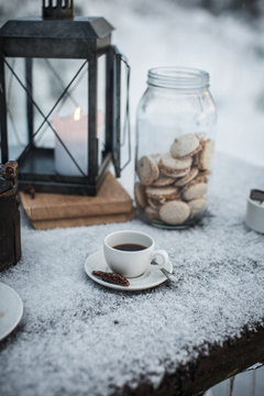 Coffee cup and biscuits on snow covered bench