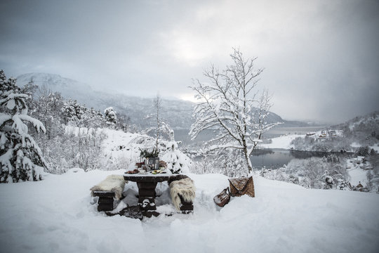 Snow covered landscape, picnic bench and fur pelts 