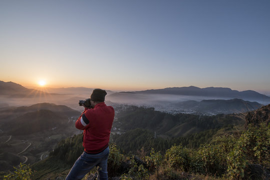 Photographer in action, clicking a beautiful Himalayan Sunrise.