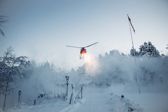Helicopter above snowy landscape, lights glowing 