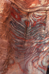 Naklejka premium Giordania, 02/10/2013: venature di diverse forme, colori e sfumature sulle rocce rosse delle tombe reali, enormi strutture funerarie scavate nella roccia nella città archeologica di Petra