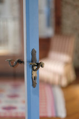 View of the room from behind a glass door with an old brass lock