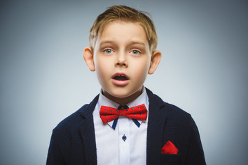 Closeup Portrait of handsome boy with astonished expression on grey background