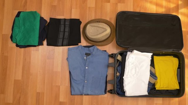 Travel concept timelapse of clothes packing into a travel suitcase