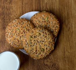 cookie with cereal grains and  glass of milk . view from above.
