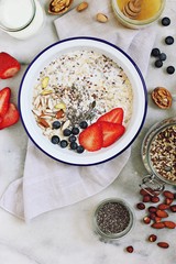 Super seeded oatmeal porridge with nuts and berries. Power breakfast with various of super food ingredients.