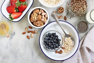 Ingredients for preparing of  overnight oats with fresh berries and various of super foods topping. Clean eating and super food concept.