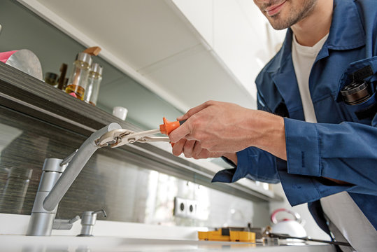 Careful handyman repairing water tap