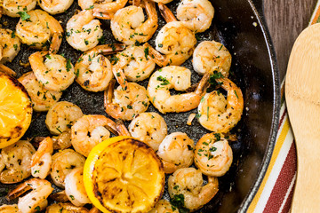 Cooked Shrimp Dinner In Cast Iron Skillet With Grilled Lemons