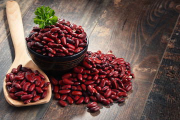 Composition with bowl of kidney bean on wooden table