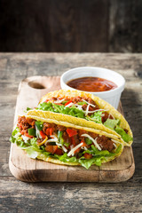 Traditional Mexican tacos with meat and vegetables on wooden background
