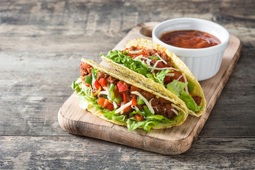 Traditional Mexican tacos with meat and vegetables on wooden background
