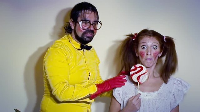 A weird salesman checking the brain of his female assistant with a hand going from one side to another. Funny comedy foolish characters.
