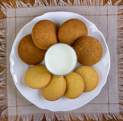 A cookie and a glass of milk for breakfast. View from above.