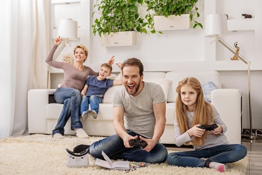 Parent And Child Playing Video Game Console