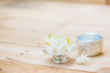 Obraz na płótnie Canvas Thailand Songkran festival decoration concept, water in silver bowl with jasmine white flower.