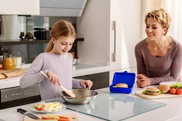 Obraz na płótnie Canvas Woman teaching her child to cook