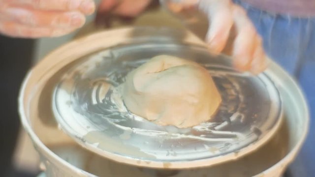 Amazing Six Year Blonde Girl is Working at a Pottery Wheel, Being Dressed in White Blose and Jeans Apron, Being Helped bt a Master