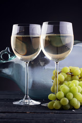 Bottle and glass of white wine, grape on wooden table