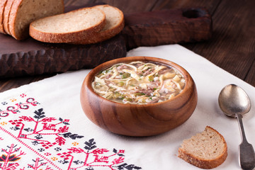 Cold Soup Okroshka in bowl and raw ingredients on wooden table