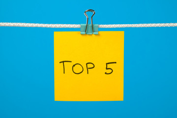 Yellow paper note on clothesline with text Top 5
