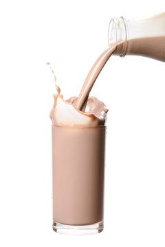 Pouring chocolate milk from bottle into glass with splashing., Isolated white background.
