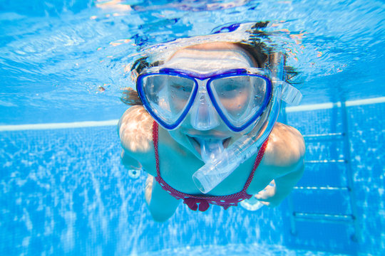 little girl  swim underwater in pool